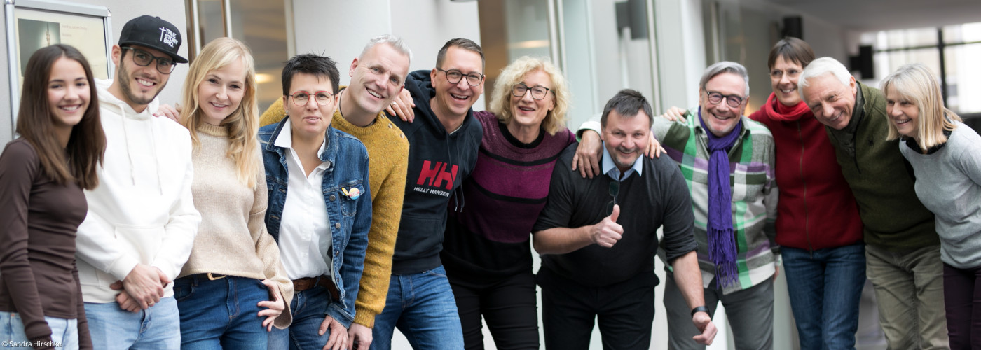 Eine Gruppe von lachenden Menschen aus unterschiedlichen Altersstufen