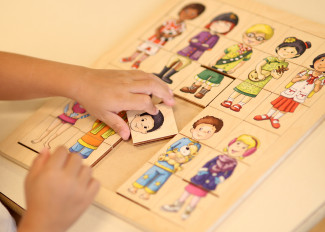 Kinderhände mit einem Puzzlespiel