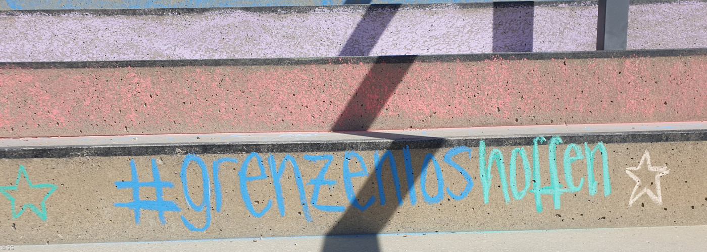 farbige Treppenstufen mit dem Schriftzug Grenzenlos hoffen