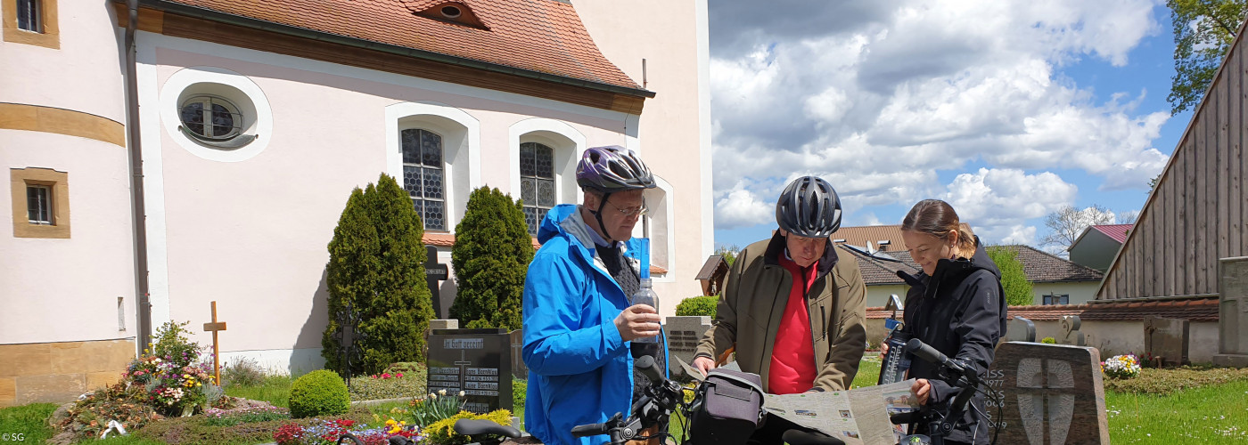 Radler vor der Kirche in Rothenstadt