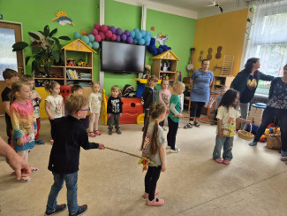 Kinder stehen im Kreis und machen ein Spiel